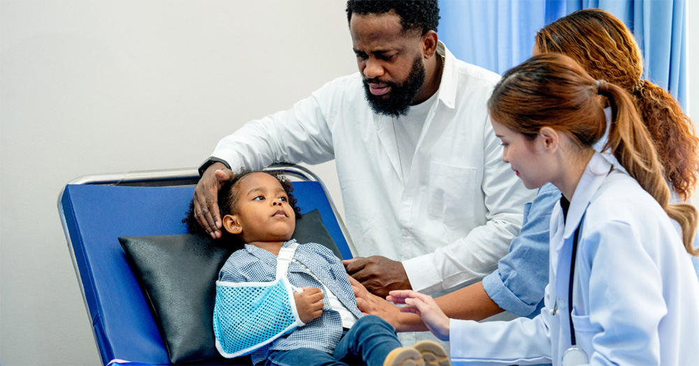 Healthcare providers care for a child with his arm in a sling
