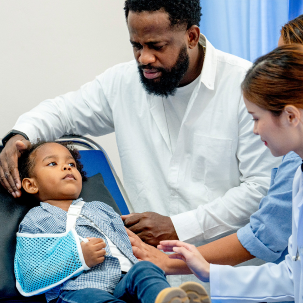 Healthcare providers care for a child with his arm in a sling